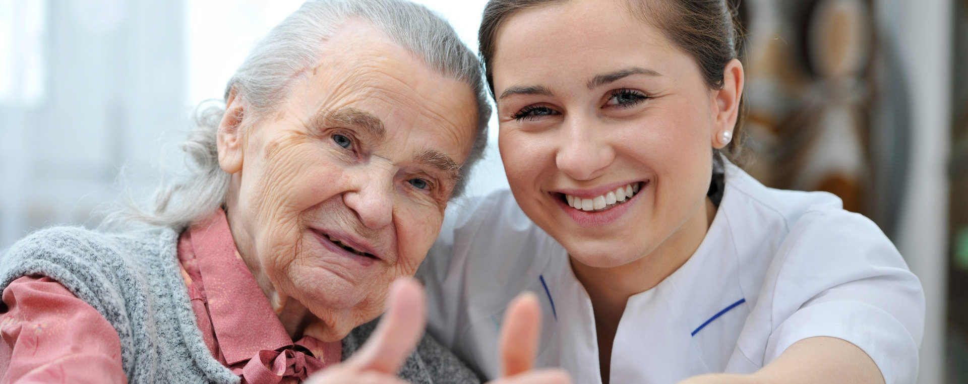 woman and an elderly woman giving thumbs up