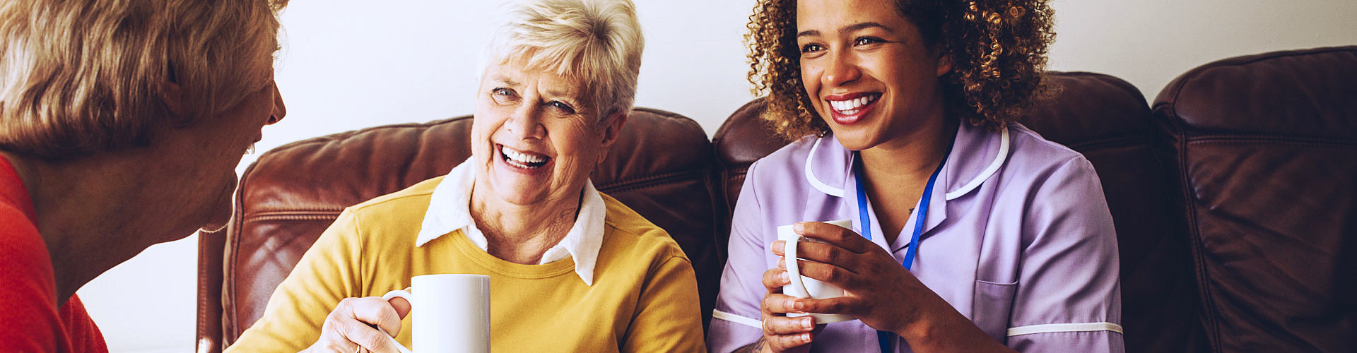 middle aged woman drinking coffee with the elderly woman